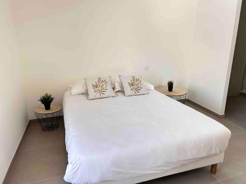 a white bed with two pillows on top of it at Néala- 4/6 pers - Standing Neuf Hyper centre in Saint-Raphaël