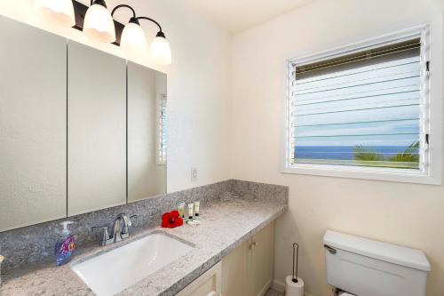 La salle de bains est pourvue d'un lavabo, de toilettes et d'une fenêtre. dans l'établissement Keauhou Kona Surf and Racquet Club Townhouse# 185, à Kailua-Kona