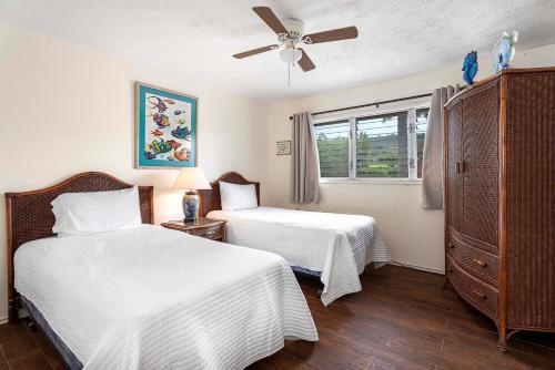a bedroom with two beds and a ceiling fan at Keauhou Kona Surf and Racquet Club Townhouse# 185 in Kailua-Kona