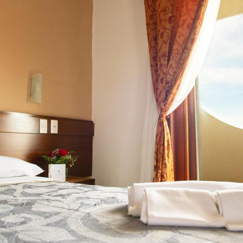 a bedroom with a bed and a window at Hotel Sinuessa Terme in Mondragone