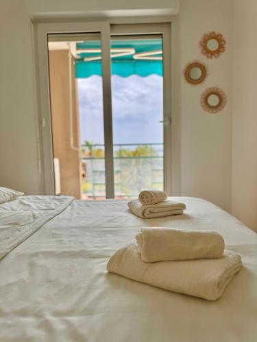 - un lit blanc avec des serviettes et une fenêtre dans l'établissement Bellissimo Appartamento Vistamare, à Antibes