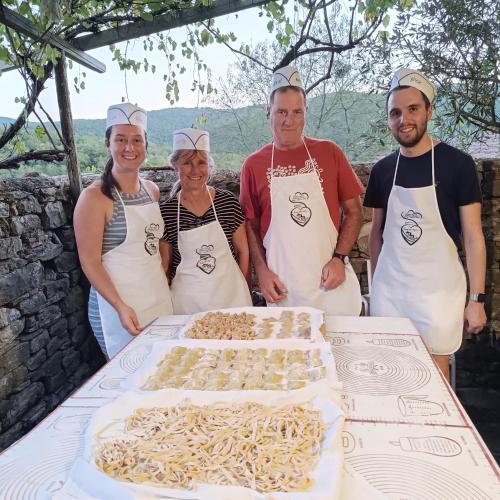 a group of people standing in front of a table with a cake at Agriturismo Podere Tegline in Radda in Chianti