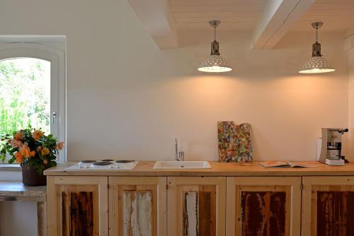 a kitchen with a sink and two pendant lights at Castello di Granarola Relais - Adults Friendly - in Gradara