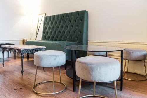 een kamer met 2 tafels en 2 krukken en een bank bij GuestReady - Mola Green in Porto