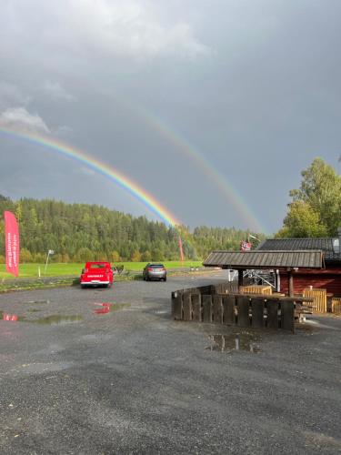 a rainbow over a parking lot with two cars at Neset Skydsstasjon in Flesberg