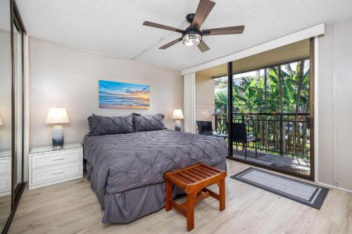 1 dormitorio con 1 cama, ventilador de techo y balcón en Kona Makai 3-203, en Kailua-Kona