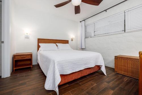 een slaapkamer met een bed en een plafondventilator bij Casa De Emdeko 204 in Kailua-Kona