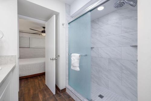 een badkamer met een douche met een glazen deur bij Casa De Emdeko 204 in Kailua-Kona