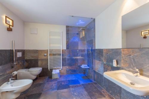 a bathroom with two sinks and two toilets at Historic Hotel Ristorante La Stua in Cavalese
