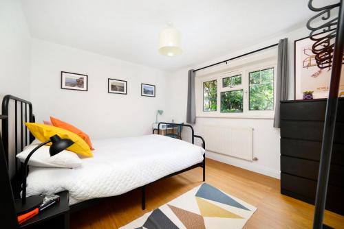 een slaapkamer met een bed en een raam bij Beautiful 1BR Flat in The Heart of Croydon in Croydon