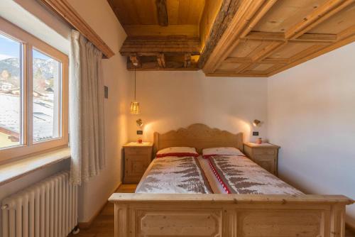 a bedroom with a bed and a window at Historic Hotel Ristorante La Stua in Cavalese