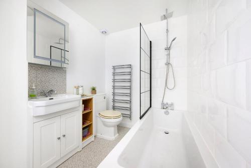 een witte badkamer met een wastafel en een toilet bij Beautiful 1BR Flat in The Heart of Croydon in Croydon