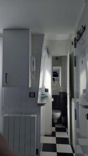 La salle de bains est pourvue d'un sol en damier noir et blanc. dans l'établissement Duplex Nôtre-Dame de Paris, à Paris