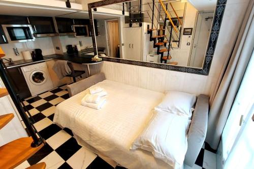 a small room with a bed and a kitchen at Duplex Nôtre-Dame de Paris in Paris