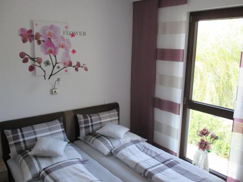 a bedroom with a bed and a window with a flower vase at Ferienwohnung im Herzen von Peitz in Peitz