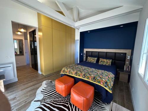 - une chambre avec un lit et deux tabourets orange dans l'établissement Belle Villa, piscine chauffée à 250m des plages, à Biarritz