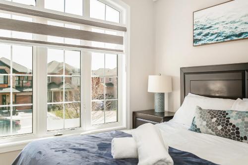 a bedroom with a bed and a large window at Pristine Pet & Smoke Free 4-Bedroom home near Canada's Wonderland in Vaughan