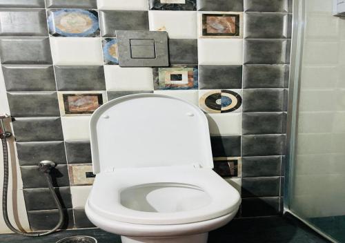 a white toilet in a bathroom with a tile wall at Best Individual Home stay Near Apollo Jubilee Hills in Hyderabad