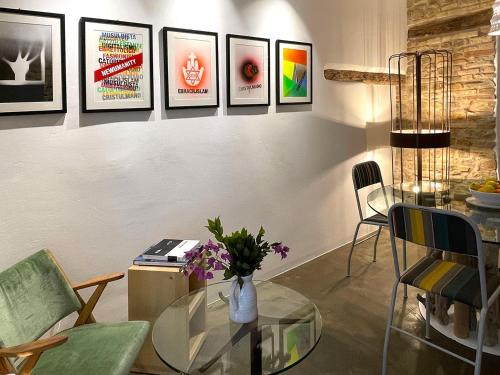 a living room with a glass table and pictures on the wall at Castello di Granarola Relais - Adults Friendly - in Gradara