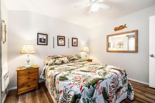 a bedroom with a bed and a dresser and a mirror at Kona Isle A4 in Kailua-Kona