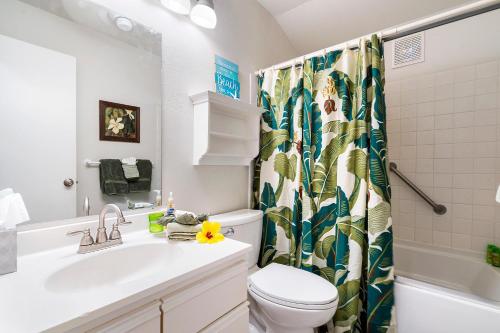 a bathroom with a sink and a toilet and a shower curtain at Kona Isle A4 in Kailua-Kona