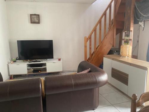 un salon avec un canapé et une télévision à écran plat dans l'établissement Maison Gallus, à Gallargues-le-Montueux