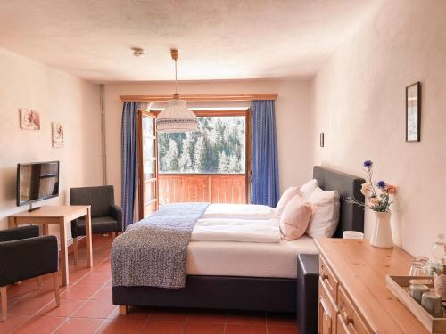um quarto com uma cama grande e uma janela em Gasthof Arriach em Arriach