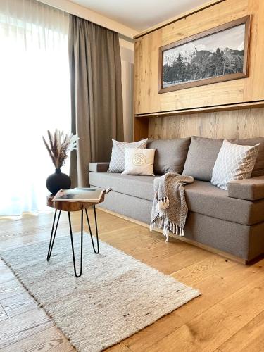 a living room with a couch and a table at moser-HOCHKÖNIG Genuss Wirtshaus Hotel in Maria Alm am Steinernen Meer