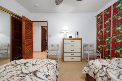 Schlafzimmer mit einem Bett, einer Kommode und Stühlen in der Unterkunft Kahaluu Bay Villas 304 in Kailua-Kona
