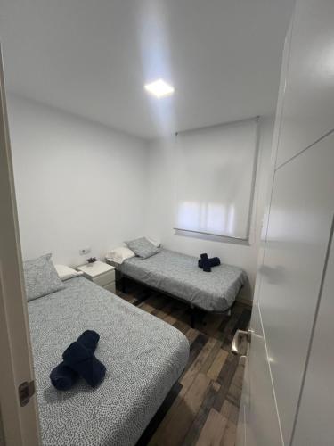 a room with two beds with black shoes on them at La Casita de Laura in Bolonia