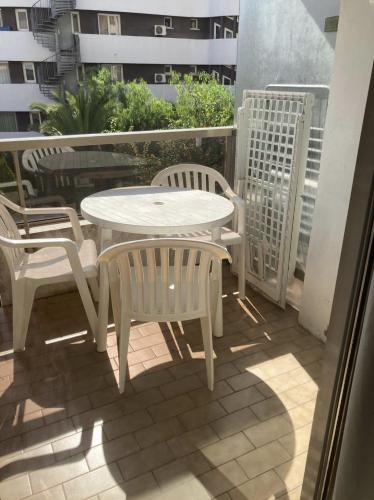une table blanche et des chaises sur un balcon dans l'établissement Résidence Graziella appartement 310, à Juan-les-Pins