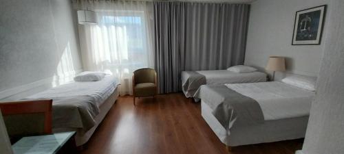 a hotel room with two beds and a window at Kauppahotelli in Lahti