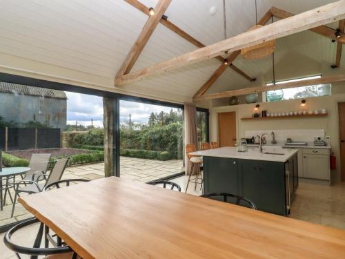 an open kitchen and dining area with a table and chairs at Hawthorn Barn in Northleach