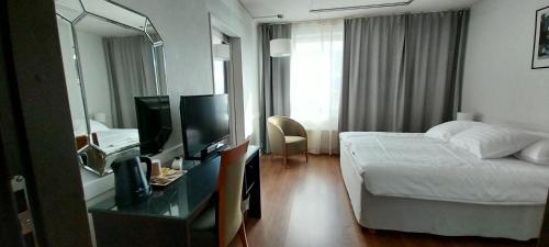 a hotel room with a bed and a mirror at Kauppahotelli in Lahti