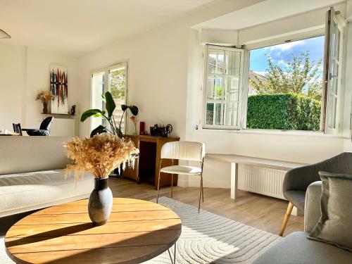 - un salon avec un vase sur une table en bois dans l'établissement Charming House 15 minutes from Paris, à Houilles