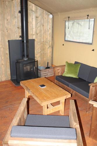 a living room with a couch and a table and a stove at The Hamlet in Warrington