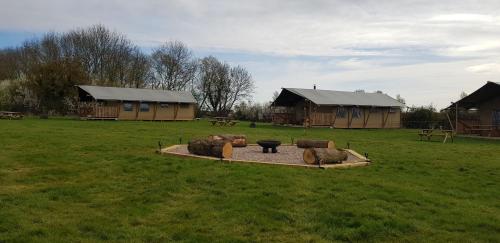 a field with a group of buildings and a fire pit at The Hamlet in Warrington