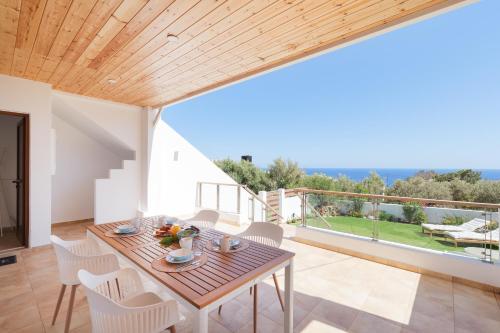een eetkamer met een tafel en stoelen en een balkon bij Sea you soon- Amazing Sea view in Achlia