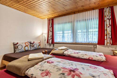 - une chambre avec 2 lits et une fenêtre dans l'établissement Ferienwohnung Metzgerbauernhof, à Wolfach