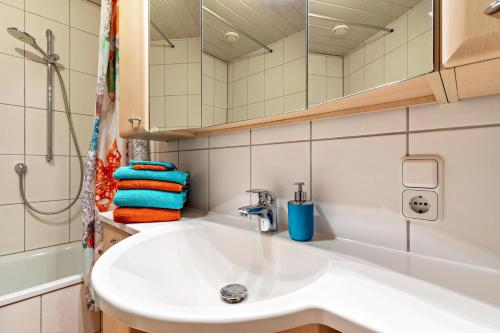 La salle de bains est pourvue d'un lavabo blanc et d'une douche. dans l'établissement Ferienwohnung Metzgerbauernhof, à Wolfach