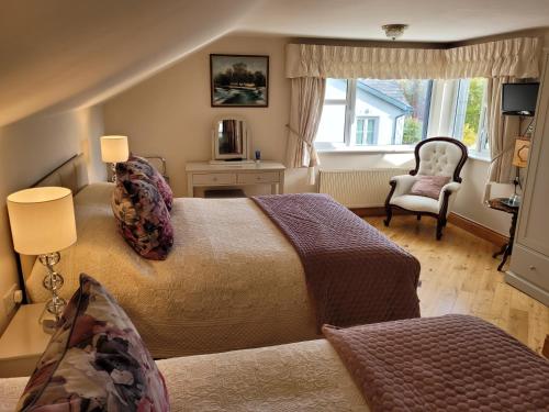 una camera con un letto e una sedia e una finestra di Rockcrest House a Kenmare