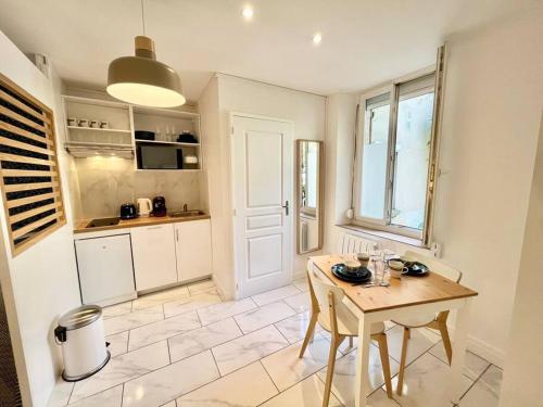 une cuisine avec une table, une petite table et une fenêtre dans l'établissement Splendide Cocon Sauna & Balnéo, à Reims