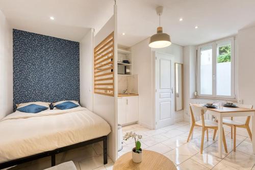 a bedroom with a bed and a table and a dining room at Splendide Cocon Sauna & Balnéo in Reims