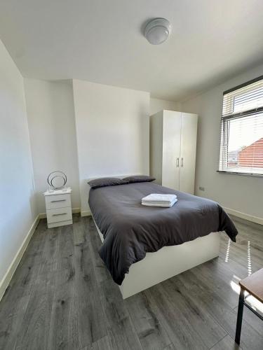 a bedroom with a large bed and a wooden floor at Wellingborough Guest House in Wellingborough