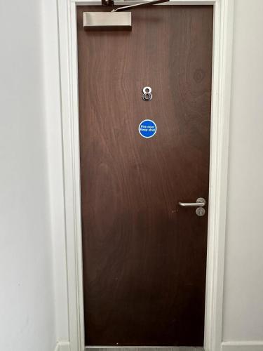 a brown door with a sign on it at Wellingborough Guest House in Wellingborough