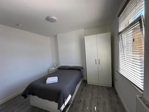 a bedroom with a bed and a large window at Wellingborough Guest House in Wellingborough