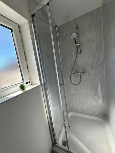 a shower with a glass door in a bathroom at Wellingborough Guest House in Wellingborough