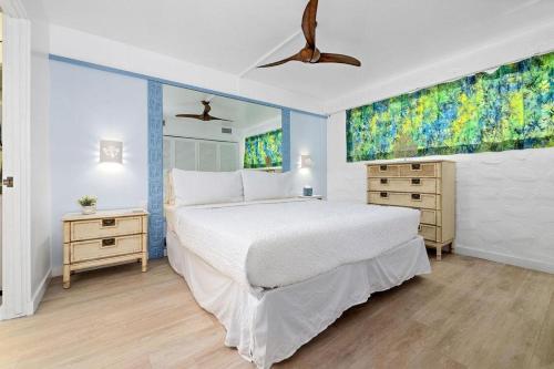 1 dormitorio con cama blanca y ventana grande en Casa De Emdeko 211, en Kailua-Kona