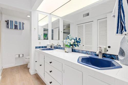 Baño blanco con 2 lavabos y aseo en Casa De Emdeko 211, en Kailua-Kona
