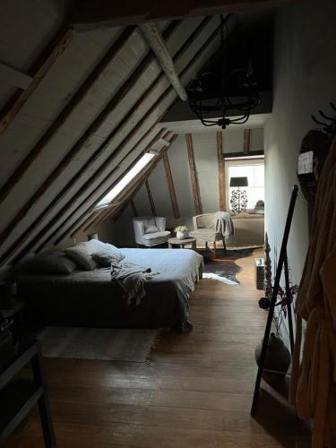 a bedroom with a bed and a couch in a attic at Bed and Breakfast Lokaal Wadway in Spanbroek